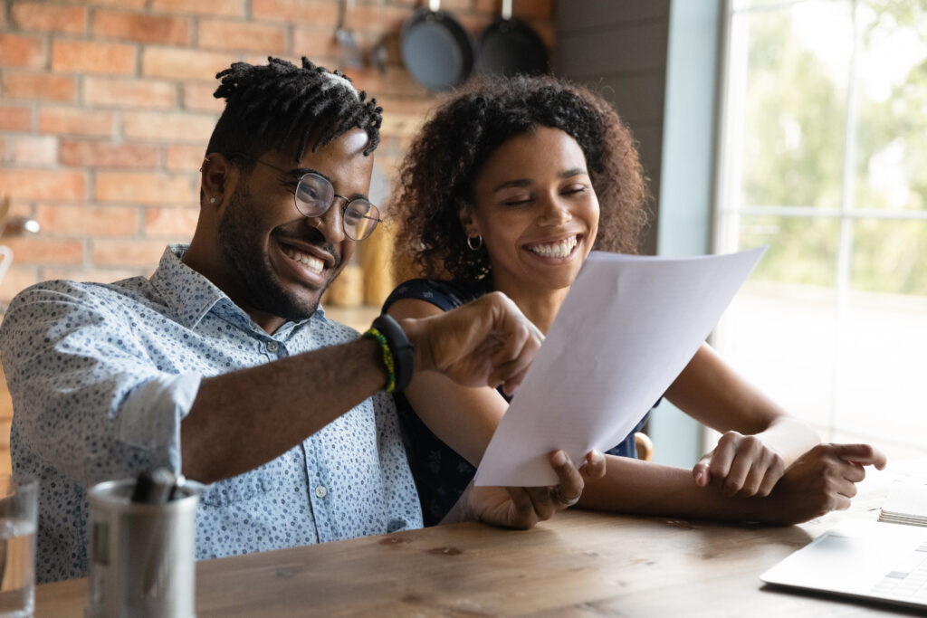 Moment of triumph on getting a mortgage Excited black couple read paper contract satisfied with good conditions
